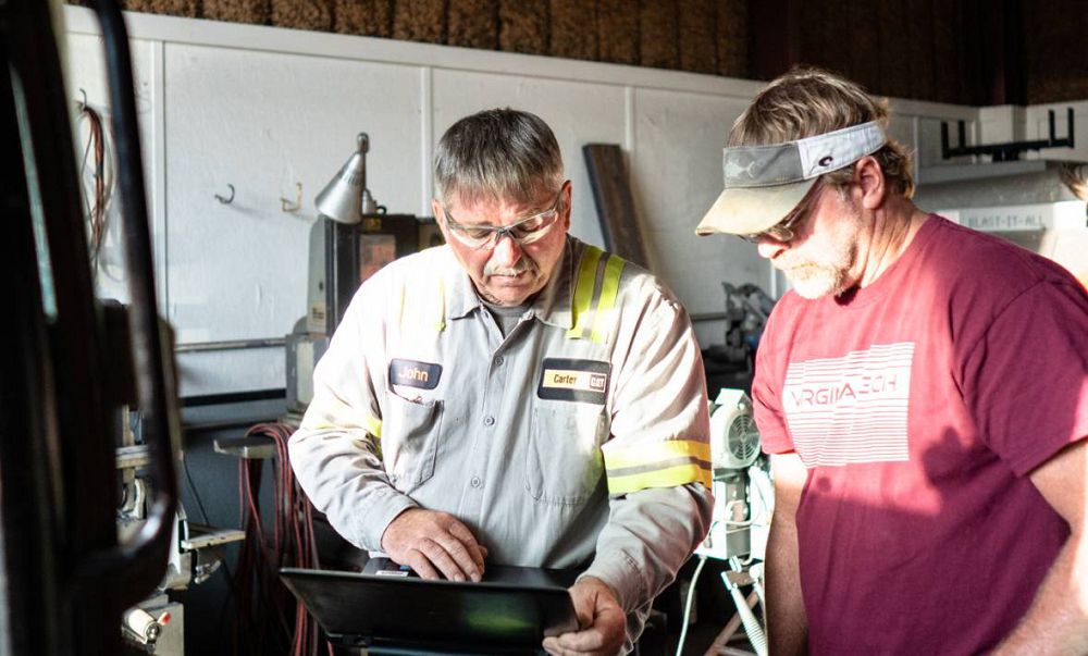 Carter Machinery Sales Associate at Client Shop Reviewing on Laptop